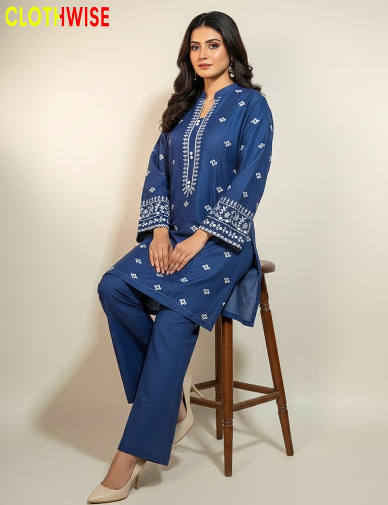 Woman wearing a blue embroidered outfit sitting on a wooden stool with 'Clothwise' branding.