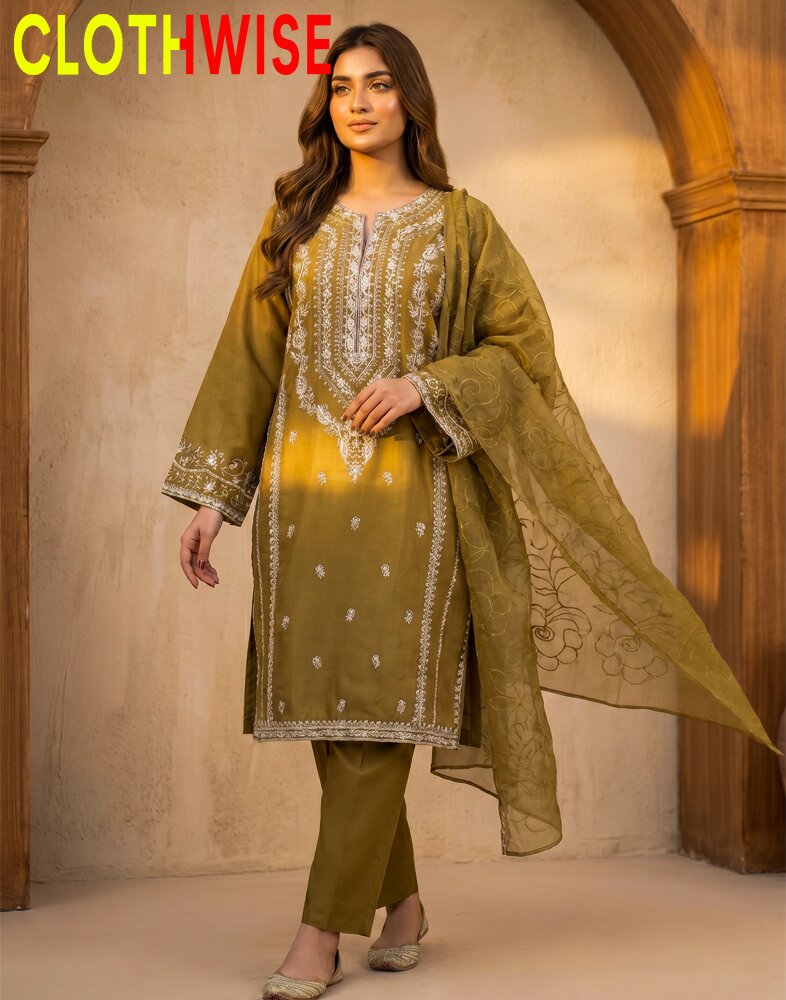 Woman wearing a green embroidered outfit with a matching dupatta against a beige wall.