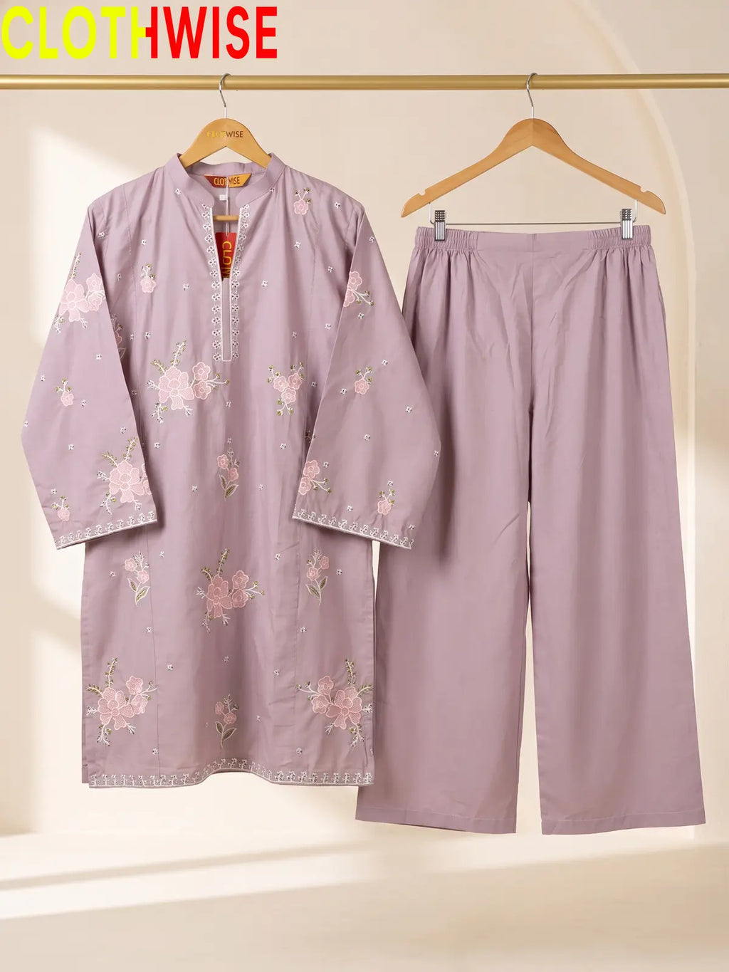 Hanger display of a onion 2-piece stitched outfit featuring a floral embroidered straight shirt and matching wide-leg trousers on a golden metal rack