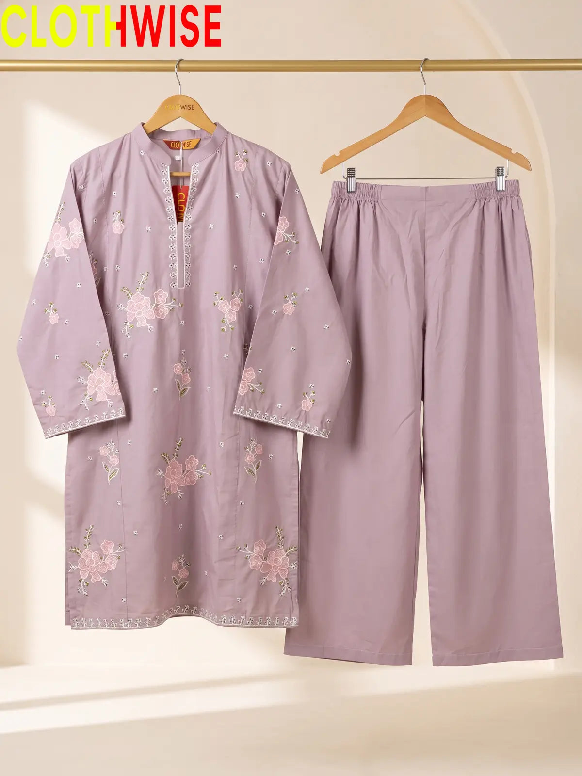 Hanger display of a onion 2-piece stitched outfit featuring a floral embroidered straight shirt and matching wide-leg trousers on a golden metal rack