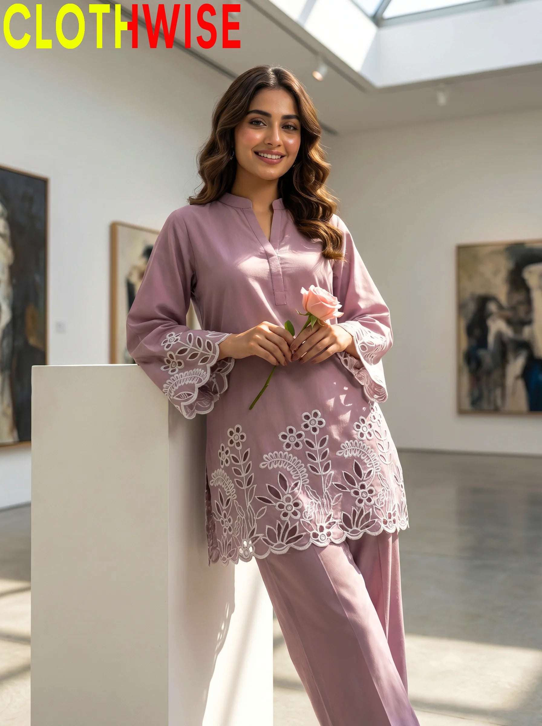Woman in a pink outfit holding a flower in an art gallery, with 'CLOTHWISE' branding.