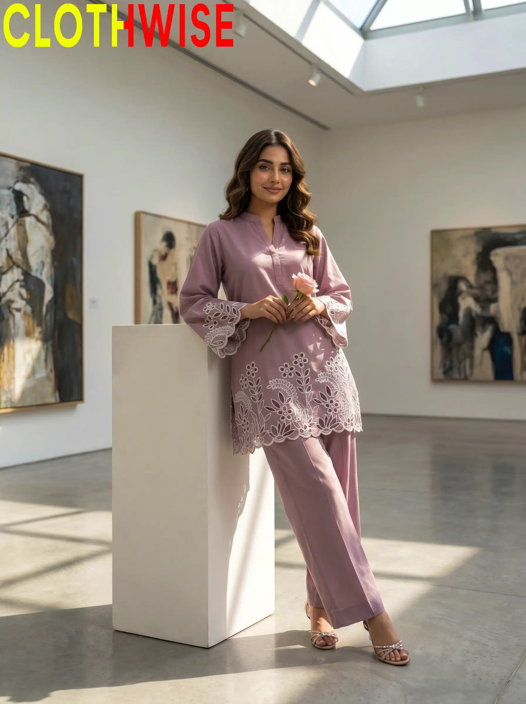 Woman in a pink outfit standing in an art gallery with 'CLOTHWISE' branding.