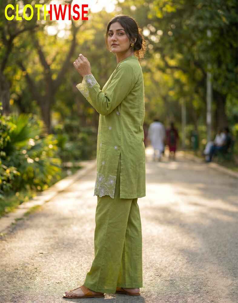 Woman in a green traditional outfit standing outdoors with 'Clothwise' branding.