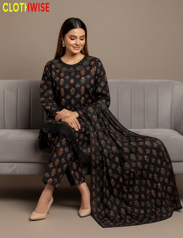 Woman sitting on a gray couch wearing a black floral dress with 'CLOTHWISE' branding.