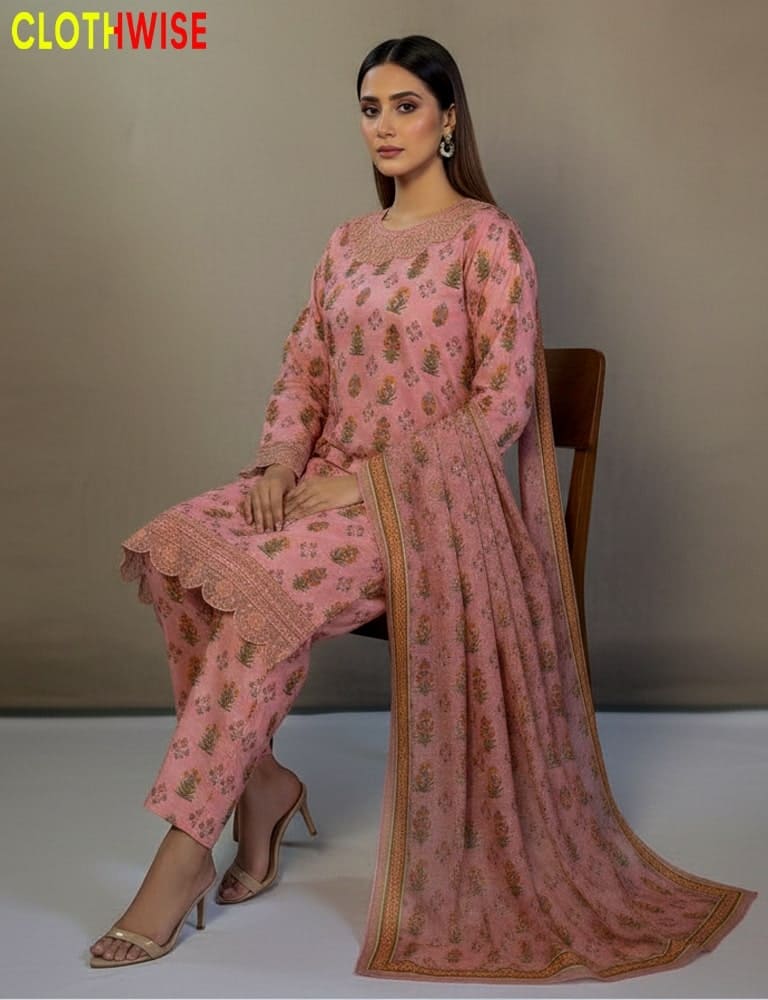 Woman wearing a pink traditional outfit with floral patterns, sitting on a chair against a plain background.