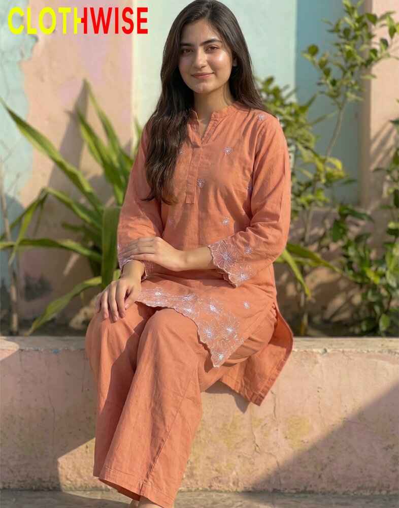 Woman wearing an orange kurta with lace details sitting outdoors, with 'CLOTHWISE' branding.