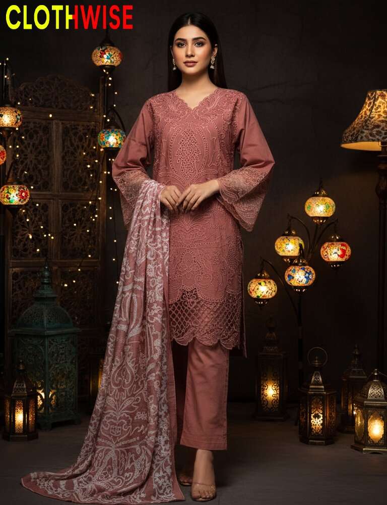 Woman in a pink traditional outfit with a matching dupatta, standing in a decorative setting with lanterns.