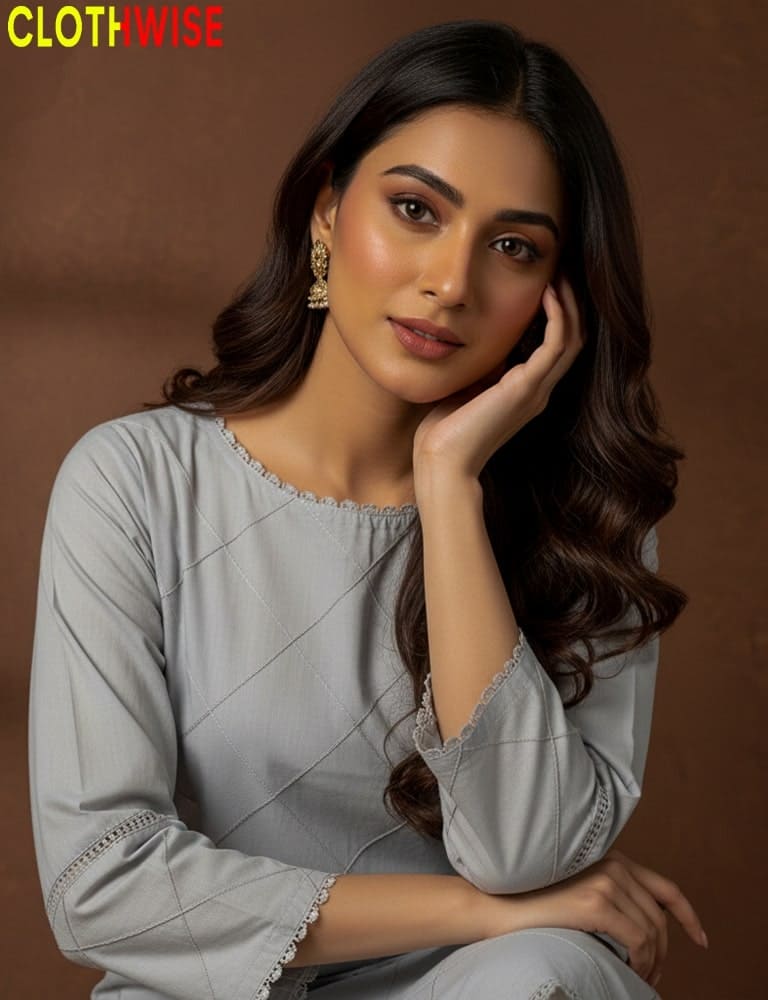 Woman wearing a light gray traditional outfit with intricate detailing, posing against a brown background. Brand 'CLOTHWISE' visible.