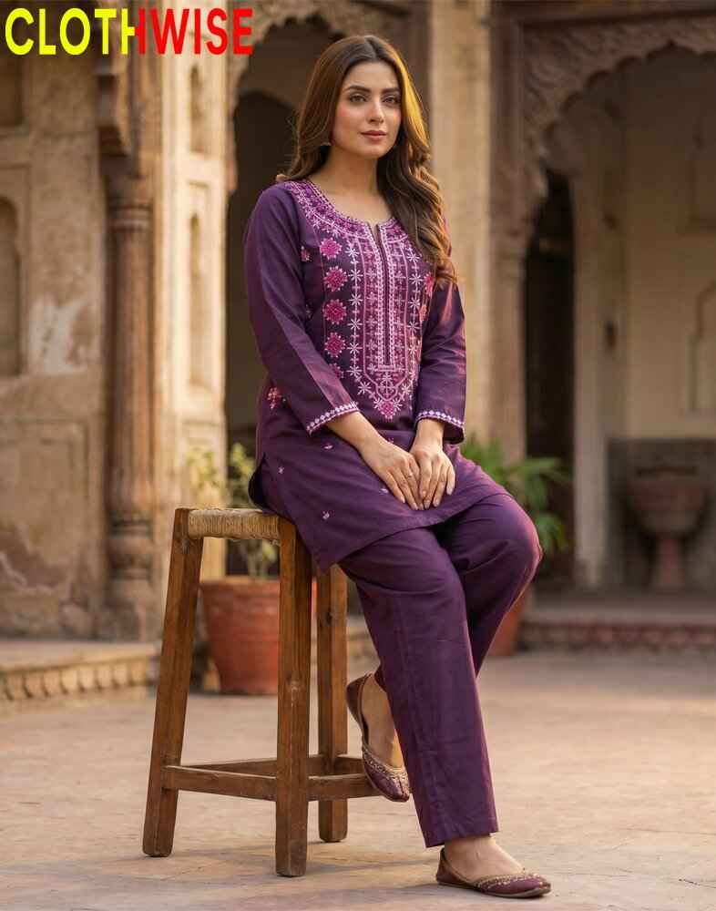 Woman in a purple embroidered outfit sitting on a wooden stool with 'CLOTHWISE' branding.