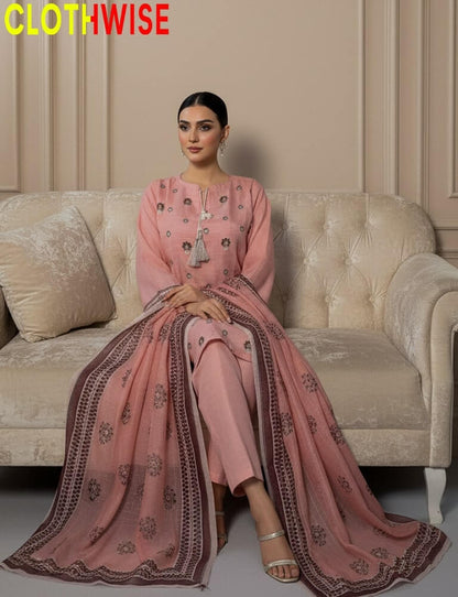 Woman in a pink traditional outfit sitting on a beige sofa with 'CLOTHWISE' branding.