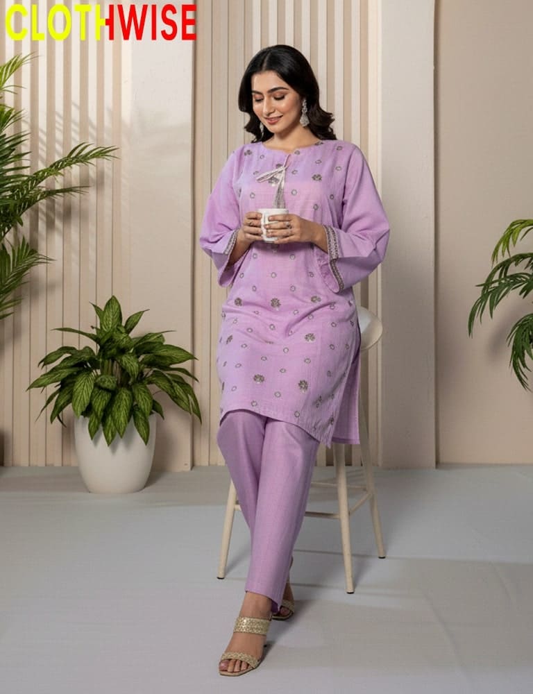 Woman in a purple outfit standing indoors with plants around