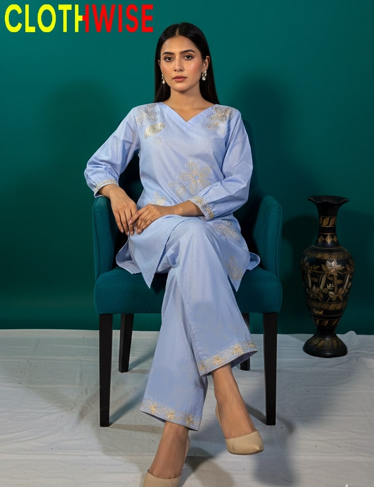 Woman in a light blue traditional outfit sitting on a chair with a teal background and 'CLOTHWISE' branding.