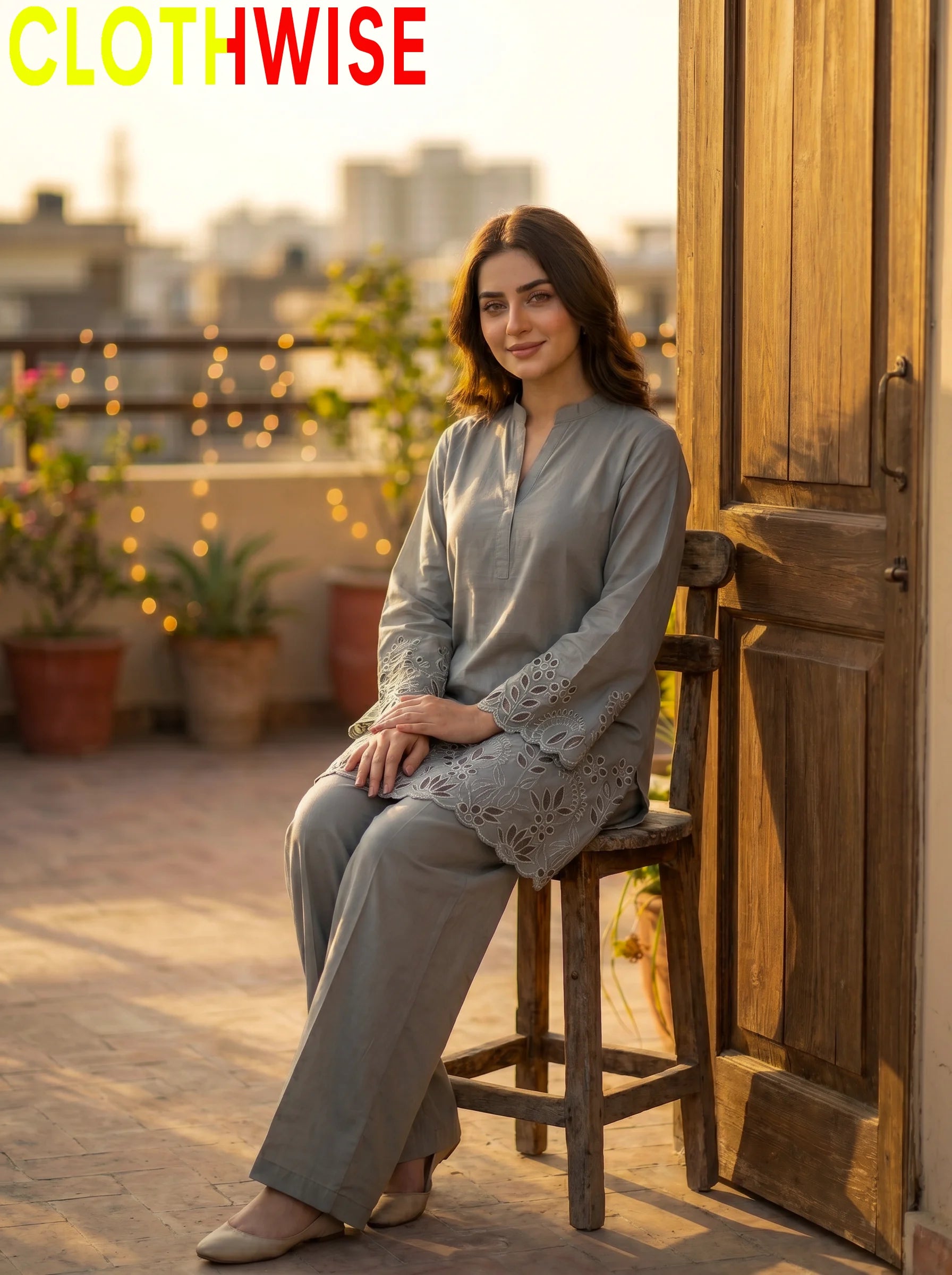 Woman sitting on a wooden stool on a rooftop with 'CLOTHWISE' branding.