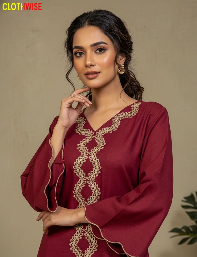 Woman wearing a maroon dress with gold embroidery against a beige background
