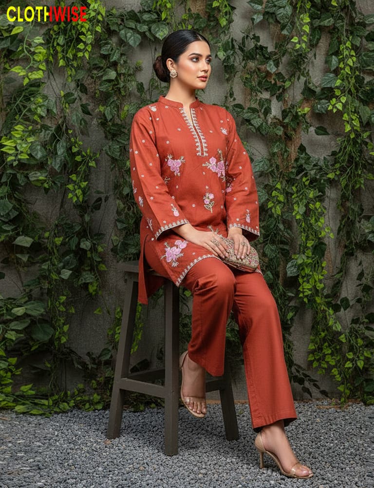 Woman in a rust-colored traditional outfit sitting on a stool against a green leafy background with 'CLOTHWISE' branding.