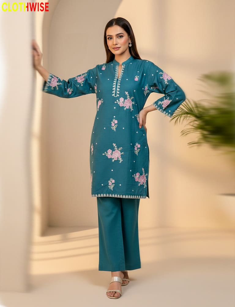 Woman wearing a teal embroidered outfit with a blurred background