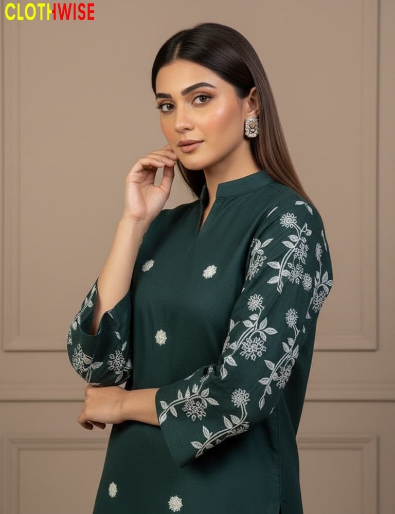 Woman wearing a green dress with floral patterns against a beige wall.