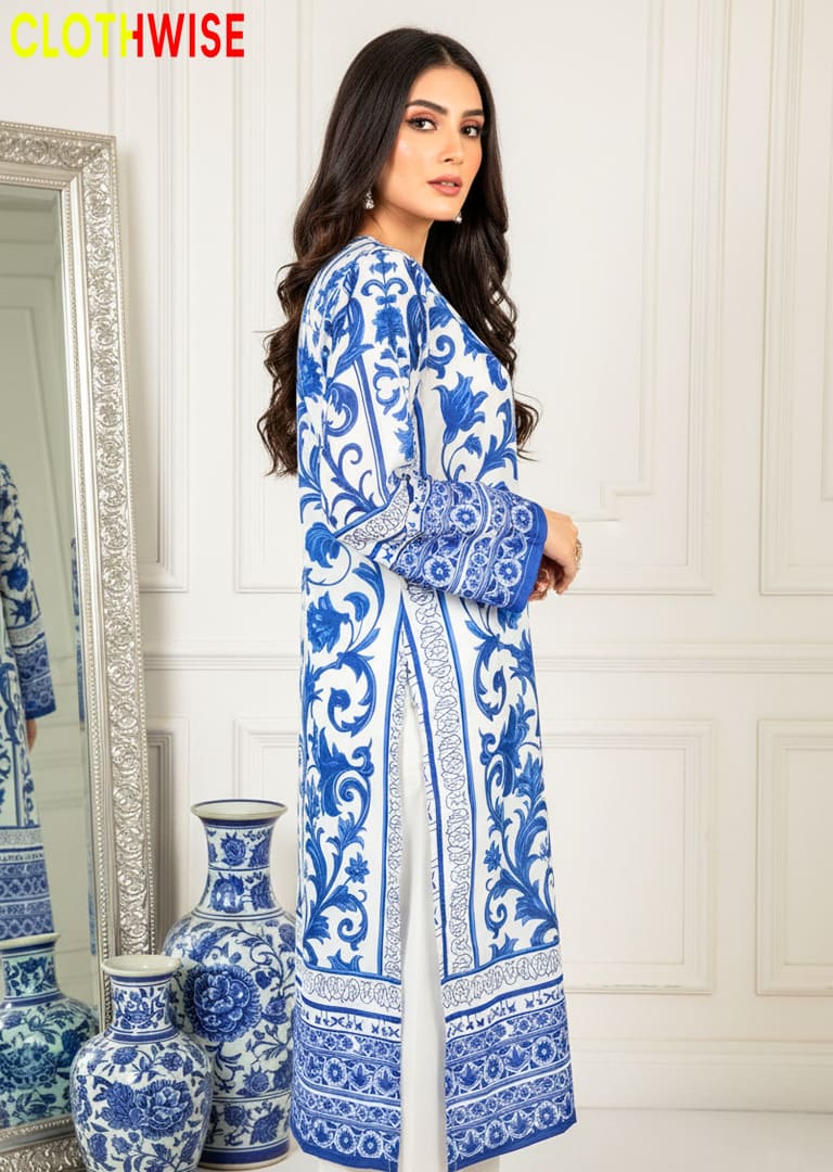 Woman wearing a blue and white patterned dress standing in front of a mirror with decorative vases.