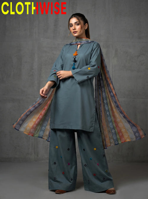 Woman wearing a teal outfit with a colorful scarf, standing against a gray background with 'CLOTHWISE' branding.