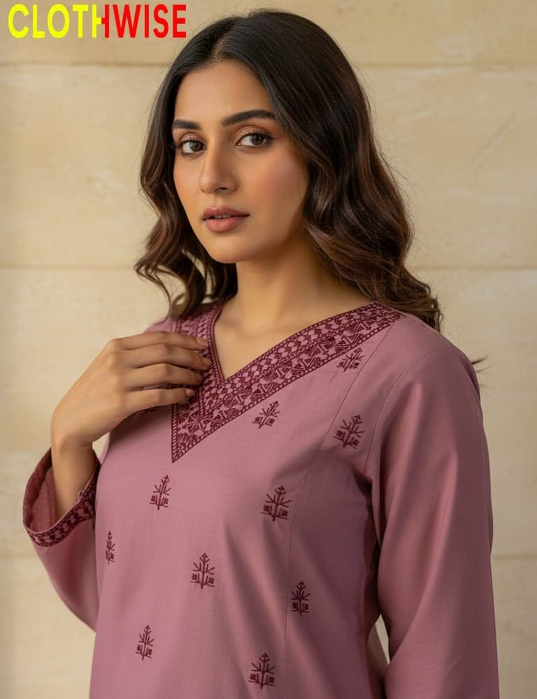 Woman wearing a pink embroidered kurta with a beige background, branded 'Clothwise'.
