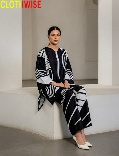 Woman wearing a black and white patterned outfit sitting on a white ledge.