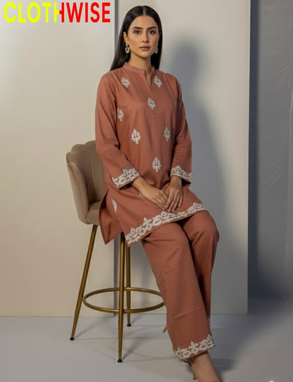 Woman sitting on a chair wearing a brown outfit with lace details, branded 'CLOTHWISE'.