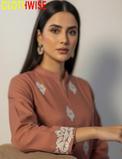 Woman wearing a brown kurta with white embroidery, sitting against a neutral background with 'CLOTHWISE' branding.