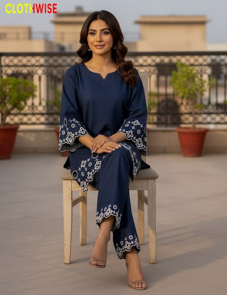 Woman in a navy blue outfit with white patterns sitting on a chair outdoors, with 'Clothwise' branding.