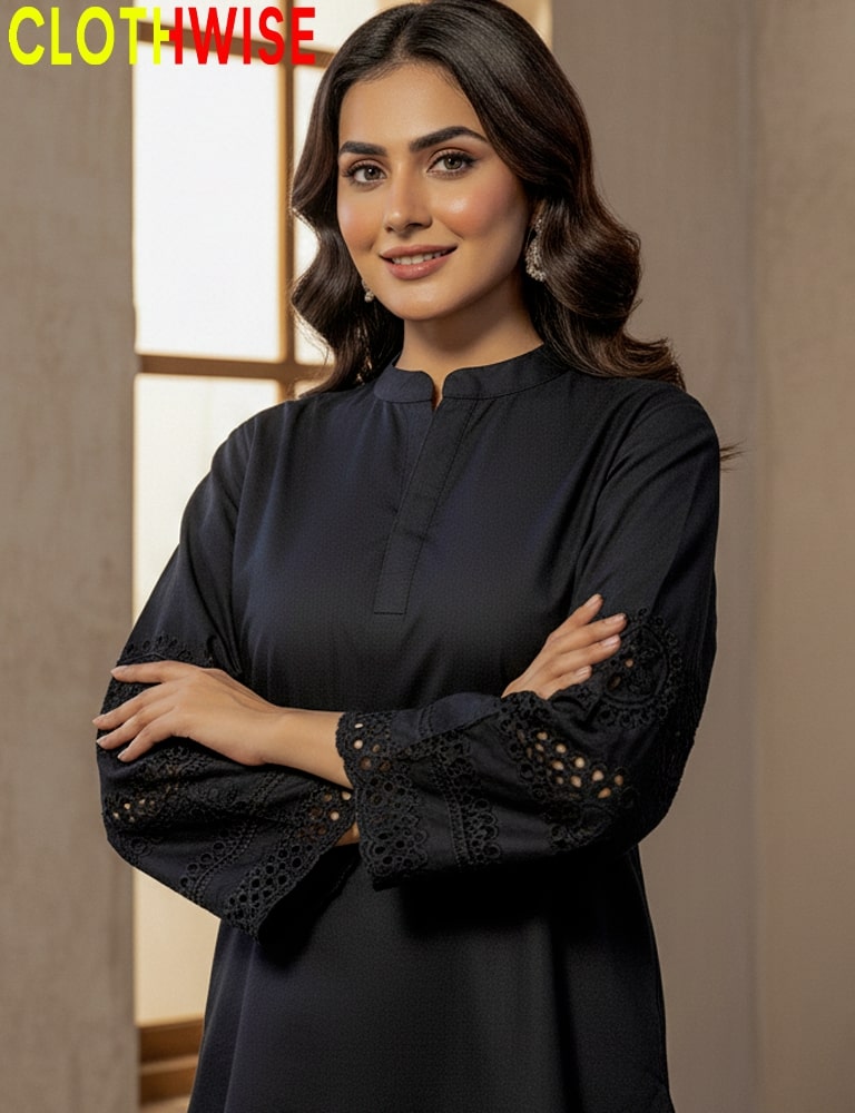 Woman wearing a black outfit with intricate arm designs, standing against a neutral background.