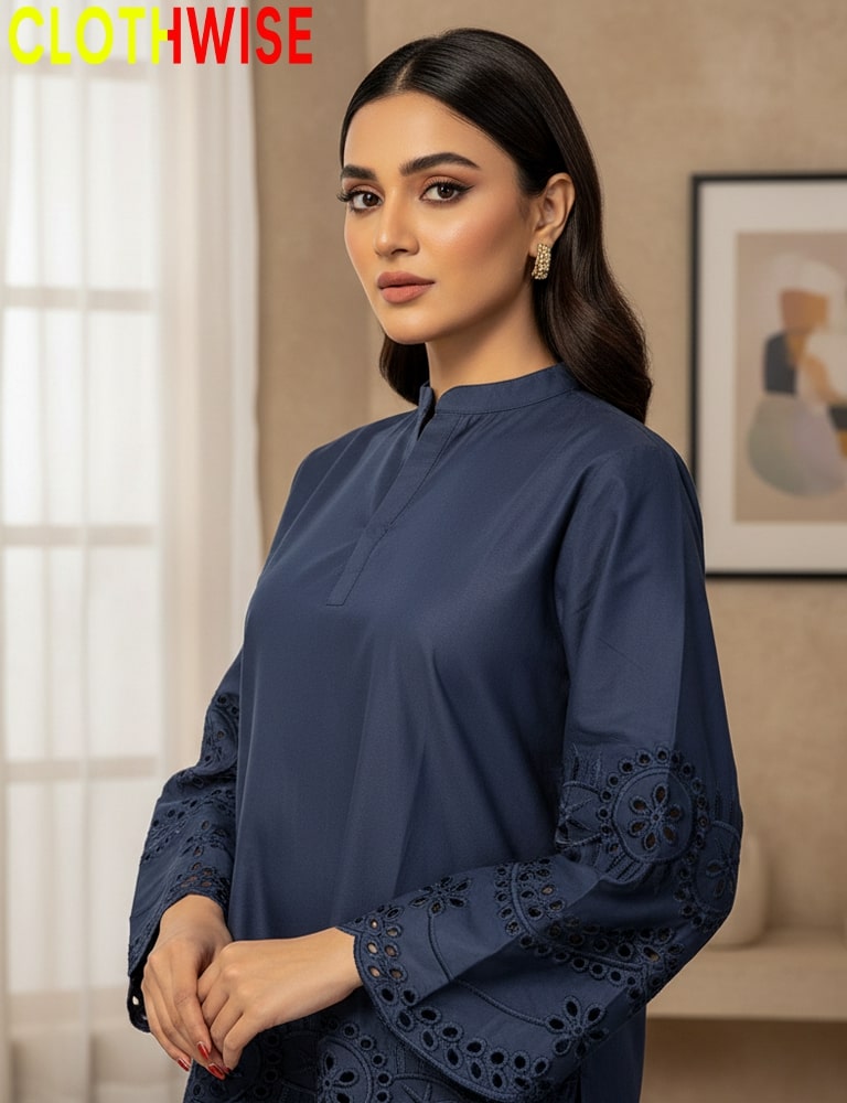 Woman wearing a navy blue outfit with intricate detailing, standing indoors.