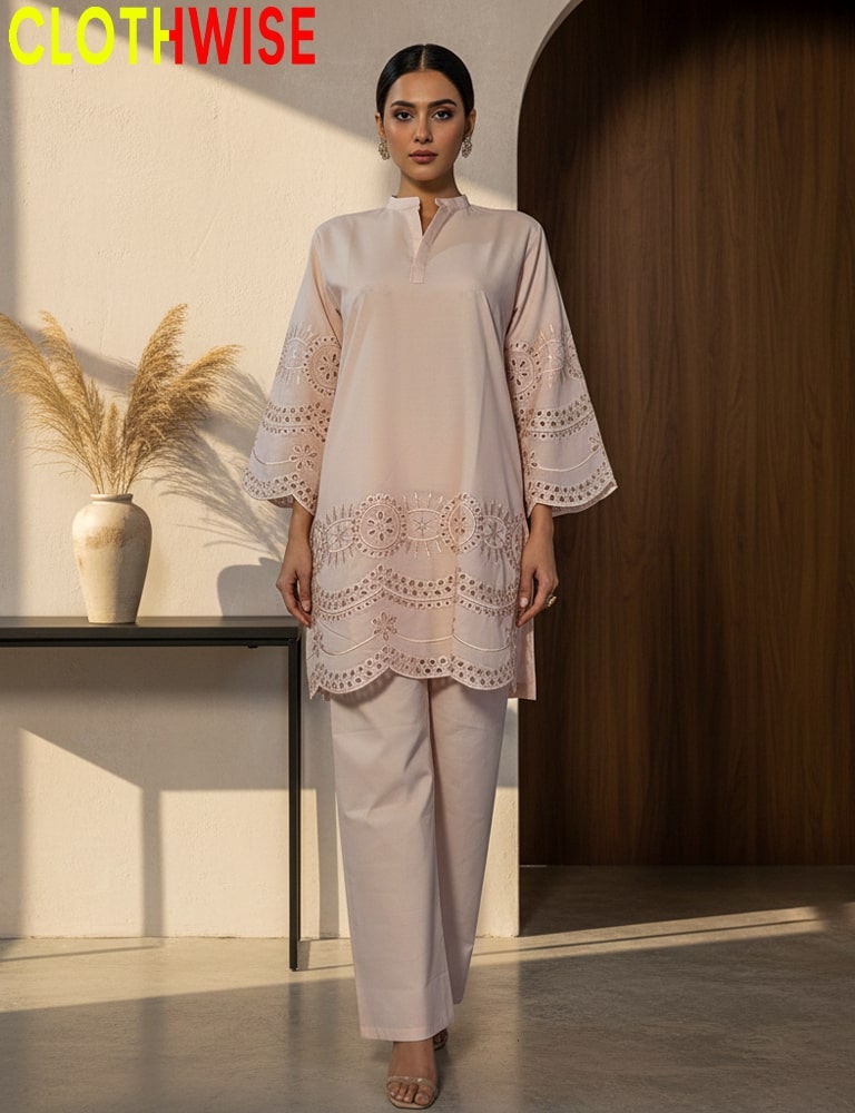 Woman wearing a light pink outfit with lace details in a minimalistic setting.