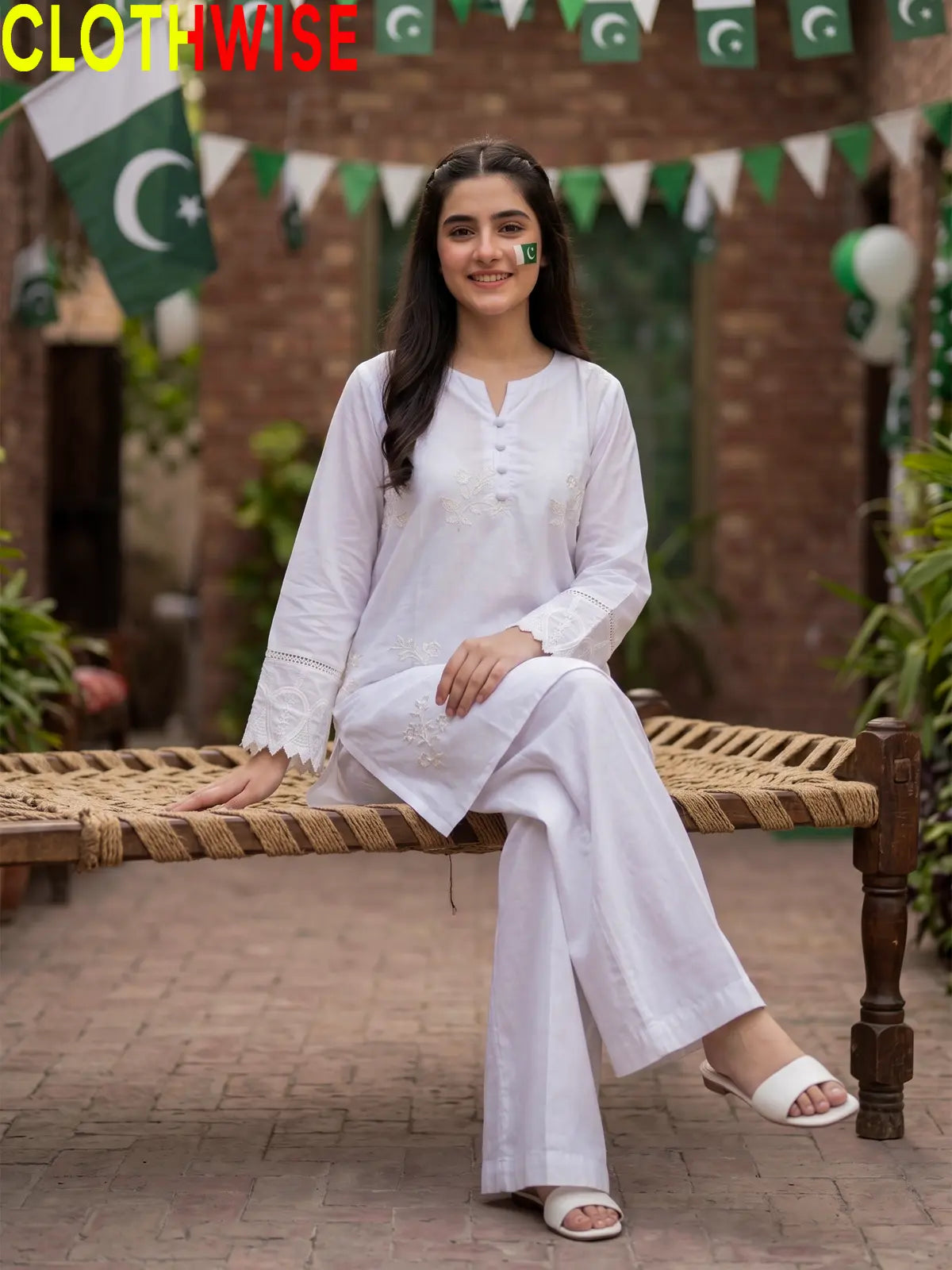 Model sitting in Azadi Booti Embroidered 2-piece lawn suit