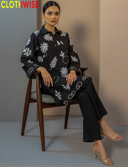 Woman sitting on a chair wearing a black floral patterned outfit with 'CLOTHWISE' branding.